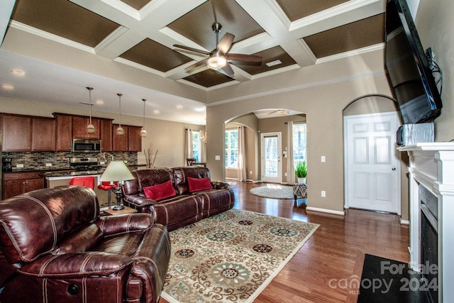 living room featuring crown molding, ceiling fan, coffered ceiling, and dark hardwood / wood-style flooring