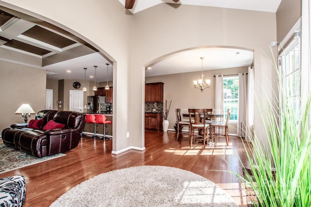 living room featuring beam ceiling, a chandelier, and wood-type flooring