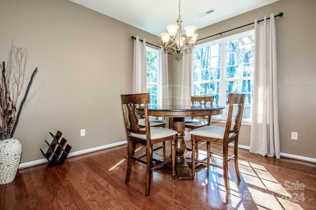 dining space with hardwood / wood-style flooring and a chandelier