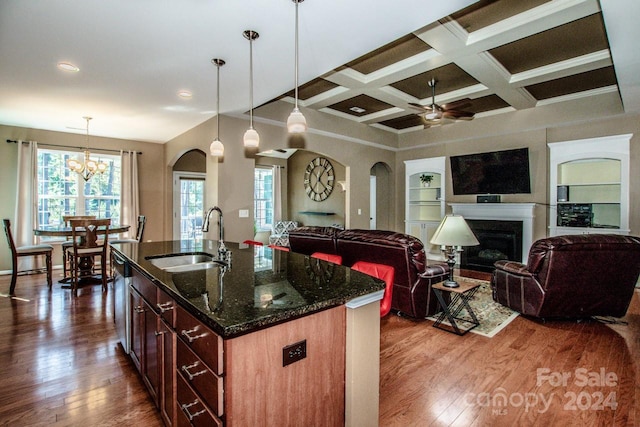 kitchen with hardwood / wood-style floors, a center island with sink, decorative light fixtures, and sink