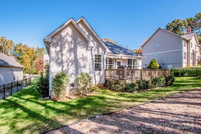 rear view of property featuring a deck and a yard