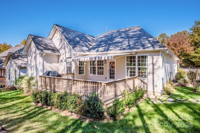 rear view of property featuring a yard and a deck