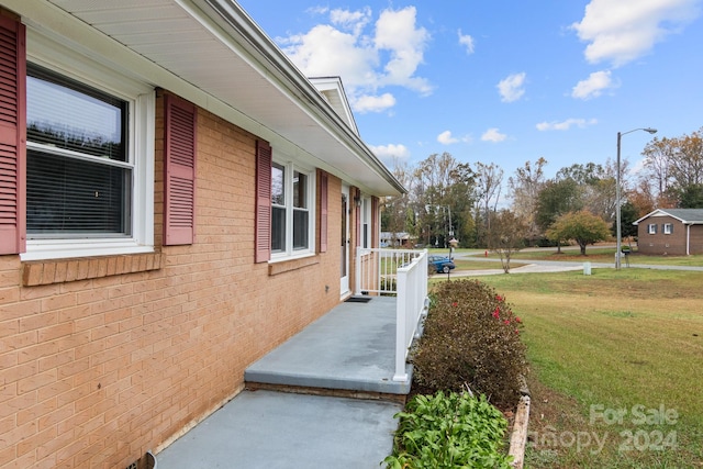 view of side of property with a lawn and covered porch