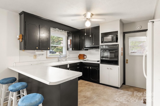 kitchen with black appliances, crown molding, sink, a breakfast bar, and kitchen peninsula