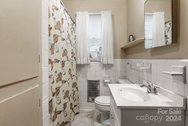 bathroom featuring tile walls, vanity, toilet, and heating unit