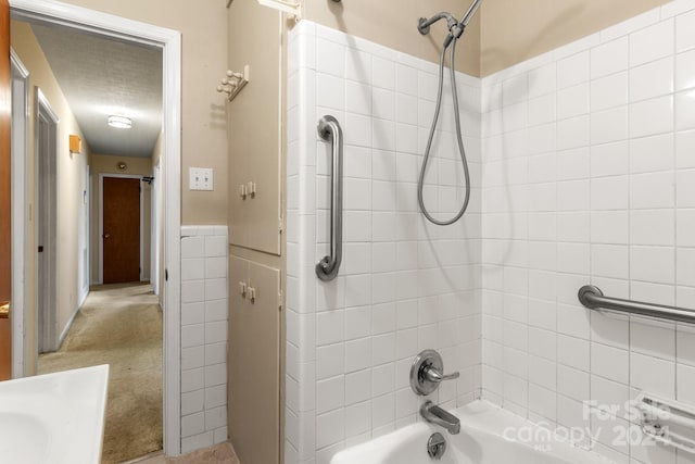 bathroom featuring tile walls and tiled shower / bath combo