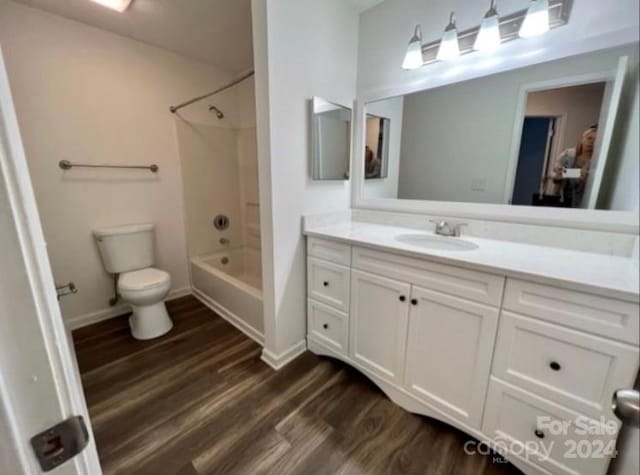 full bathroom with toilet, hardwood / wood-style flooring, vanity, and tub / shower combination