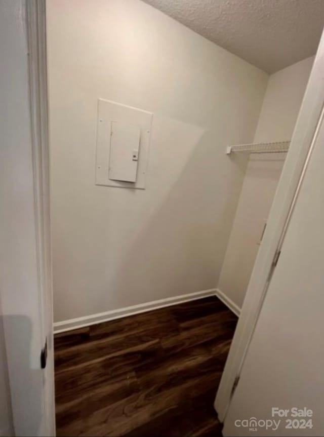 spacious closet featuring dark wood-type flooring and electric panel