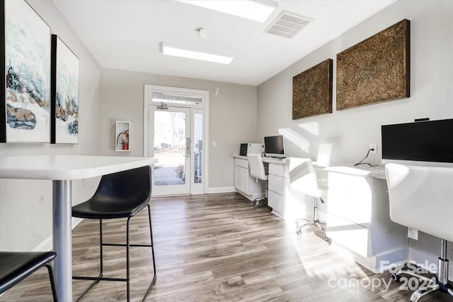 home office featuring hardwood / wood-style floors and built in desk