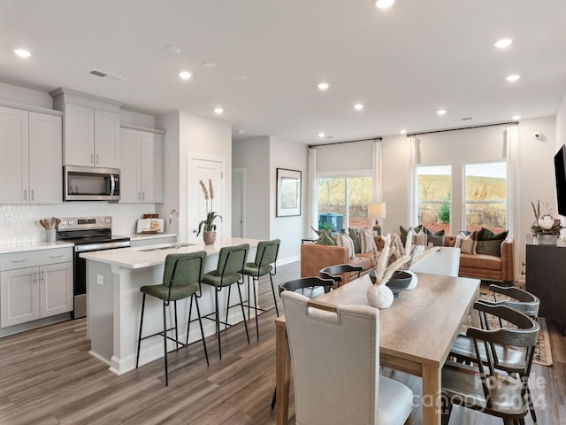 dining area featuring sink and wood-type flooring