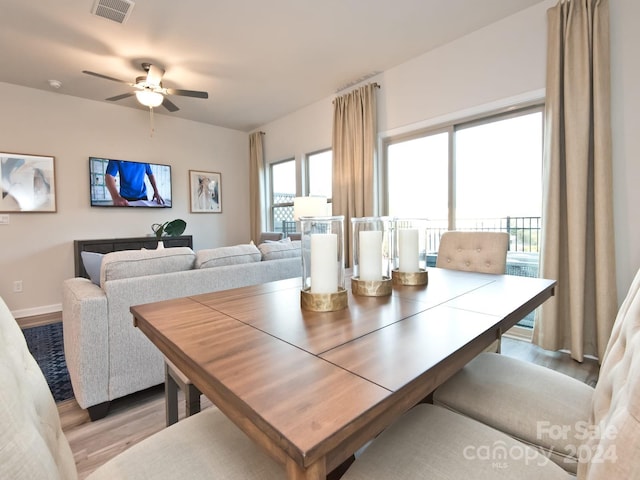 dining space with ceiling fan and light wood-type flooring