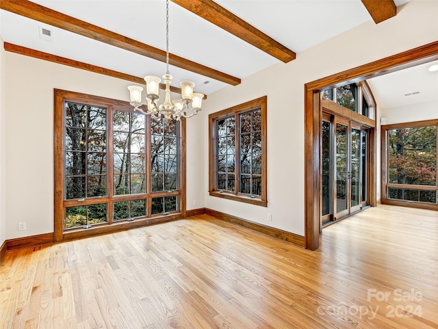 unfurnished dining area with light wood-type flooring, a chandelier, and beam ceiling