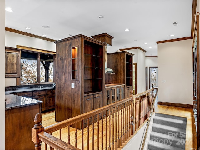 hallway featuring light hardwood / wood-style flooring, sink, and crown molding