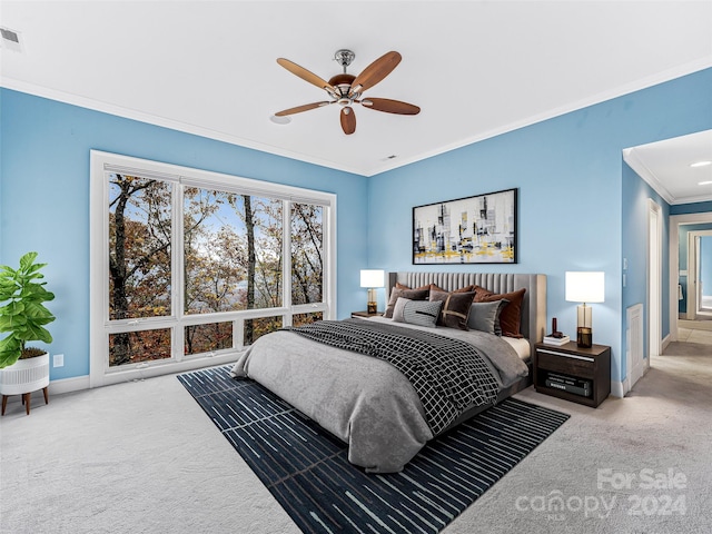 carpeted bedroom featuring ceiling fan and crown molding