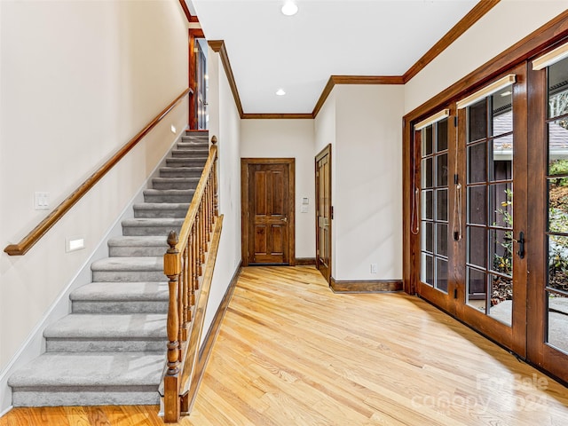 entryway featuring french doors, light hardwood / wood-style floors, and crown molding