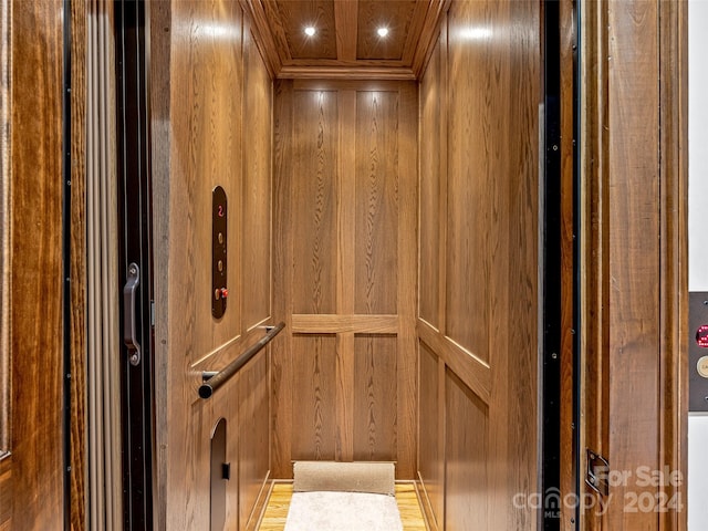 room details featuring hardwood / wood-style flooring, elevator, and wooden walls