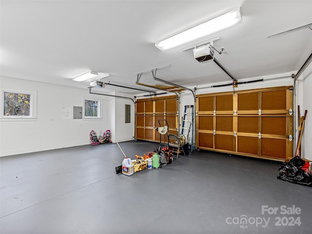 garage with electric panel and a garage door opener