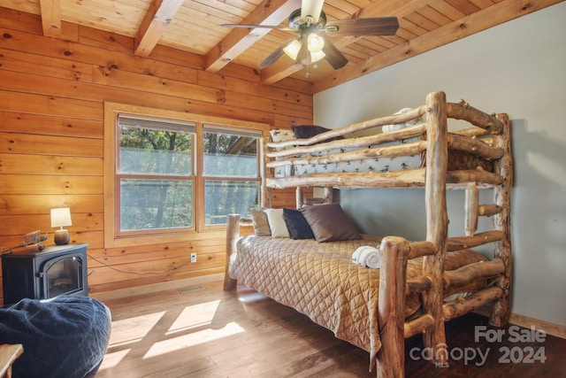 bedroom with beam ceiling, ceiling fan, wooden ceiling, wood-type flooring, and wooden walls