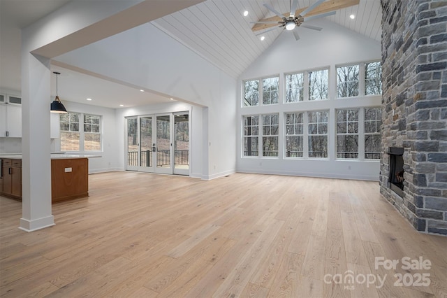 6630 Vesuvius Furnace Rd Unit 1, Denver, NC 28037 - unfurnished living room with a ceiling fan, baseboards, high vaulted ceiling, a stone fireplace, and light wood-style floors