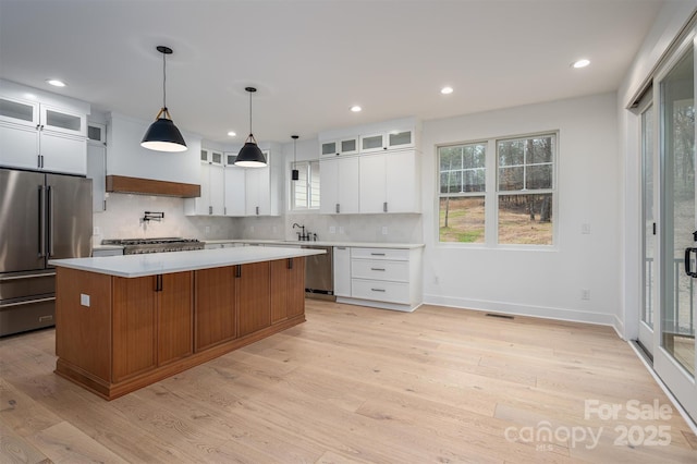 6630 Vesuvius Furnace Rd Unit 1, Denver, NC 28037 - kitchen featuring light wood finished floors, a kitchen island, light countertops, appliances with stainless steel finishes, and backsplash