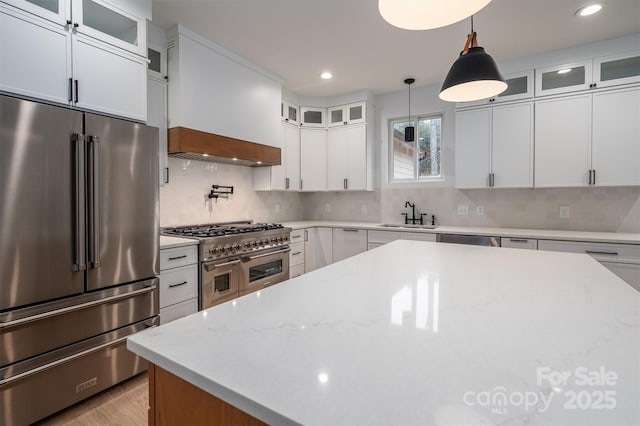 6630 Vesuvius Furnace Rd Unit 1, Denver, NC 28037 - kitchen featuring premium range hood, a sink, premium appliances, decorative backsplash, and hanging light fixtures