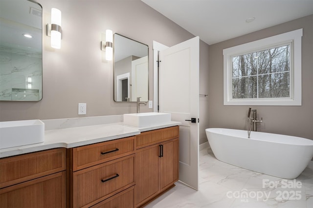 6630 Vesuvius Furnace Rd Unit 1, Denver, NC 28037 - bathroom featuring double vanity, marble finish floor, a freestanding bath, and a sink