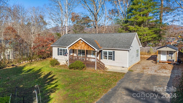 view of front of house with a porch, a storage shed, a trampoline, and a front yard