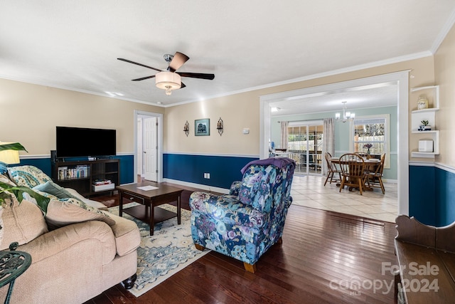 living room with hardwood / wood-style floors, ceiling fan with notable chandelier, and ornamental molding