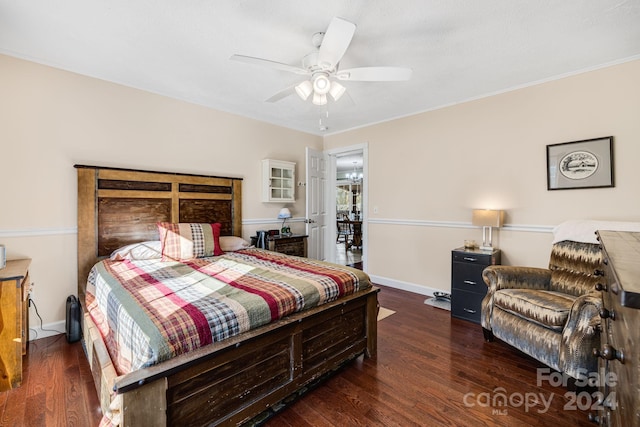 bedroom with dark hardwood / wood-style flooring, ceiling fan, and crown molding