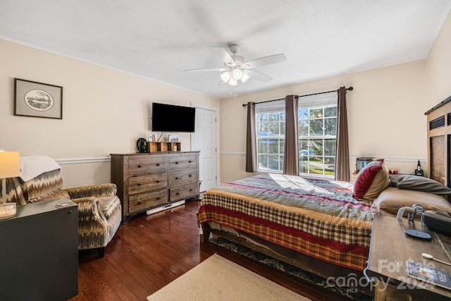 bedroom featuring ceiling fan, dark hardwood / wood-style floors, ornamental molding, and a closet