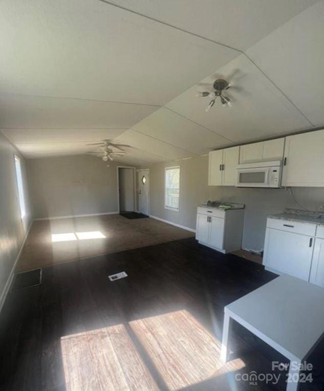 kitchen featuring lofted ceiling, white cabinets, dark hardwood / wood-style floors, and ceiling fan