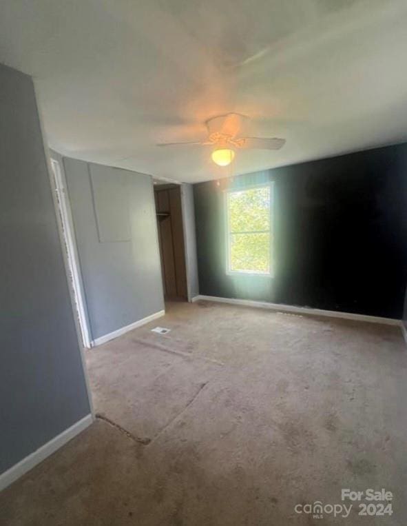 unfurnished bedroom featuring light carpet and ceiling fan