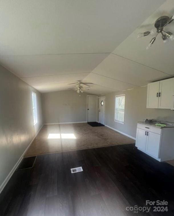 unfurnished living room with ceiling fan, a healthy amount of sunlight, and dark hardwood / wood-style flooring