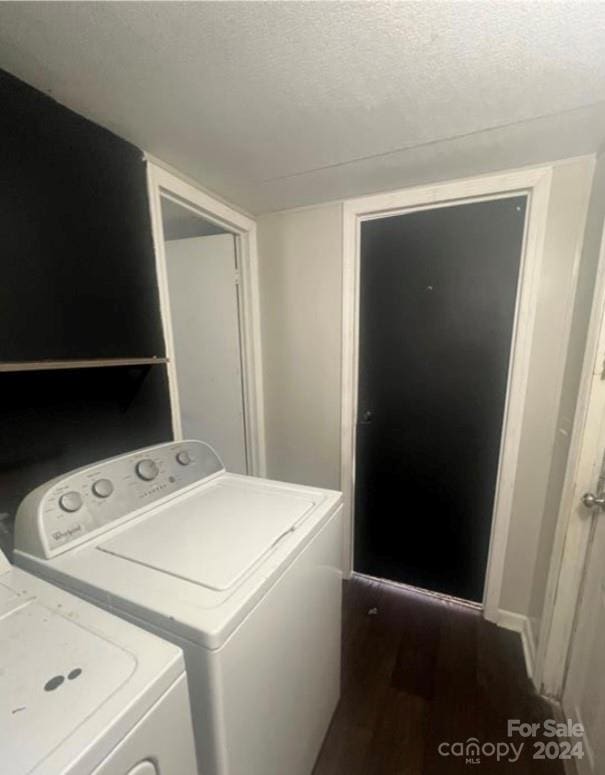 laundry area with washer and clothes dryer, a textured ceiling, and dark hardwood / wood-style flooring