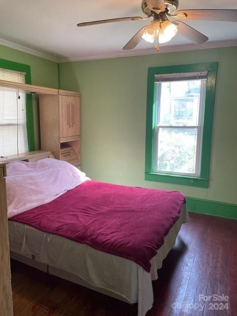 bedroom featuring ornamental molding, multiple windows, dark hardwood / wood-style floors, and ceiling fan