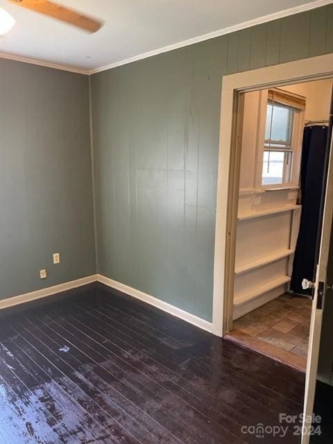 empty room featuring ornamental molding, ceiling fan, and dark hardwood / wood-style flooring