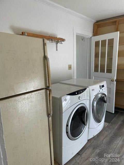 clothes washing area featuring crown molding, dark hardwood / wood-style floors, and separate washer and dryer