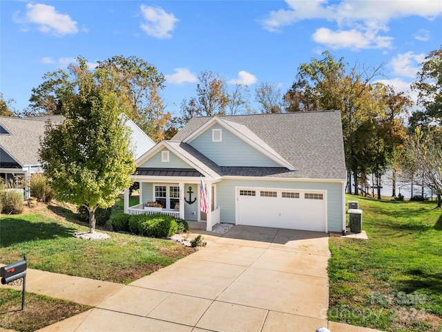 view of front of house with a front yard, a garage, and covered porch