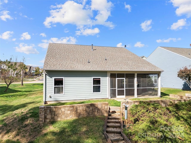 rear view of property featuring a yard and a sunroom