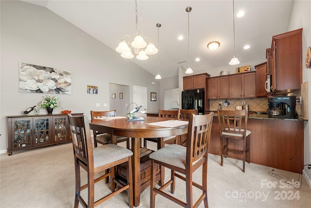 dining room featuring a notable chandelier, light colored carpet, and high vaulted ceiling