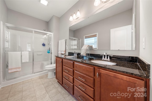 bathroom with vanity, tile patterned floors, toilet, and walk in shower