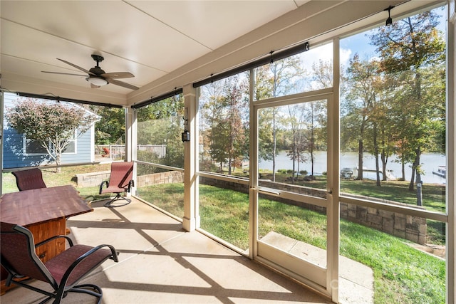 sunroom / solarium with a water view, ceiling fan, and a wealth of natural light