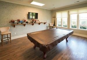 rec room with dark wood-type flooring, crown molding, and billiards