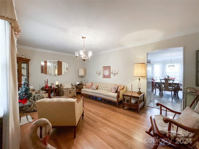 living room featuring wood-type flooring, a chandelier, and ornamental molding