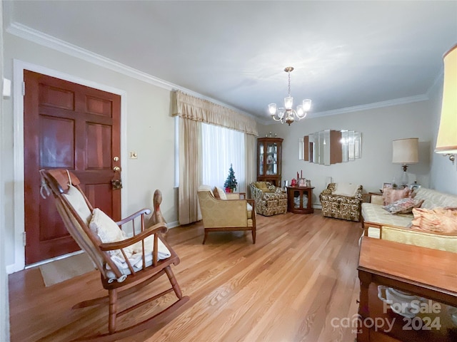 sitting room featuring a notable chandelier, ornamental molding, and light hardwood / wood-style flooring