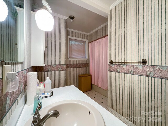 bathroom featuring tile patterned flooring, vanity, and crown molding