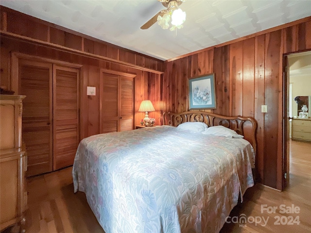 bedroom with wooden walls and ceiling fan