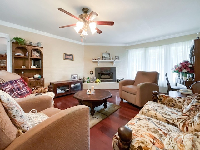 living room with dark wood-type flooring, ceiling fan, and crown molding