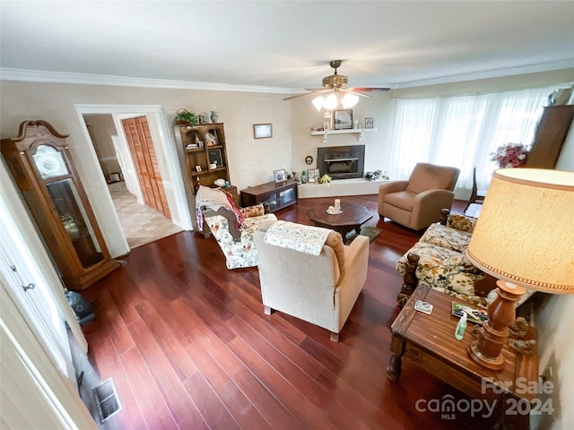 living room featuring ornamental molding, dark wood-type flooring, and ceiling fan