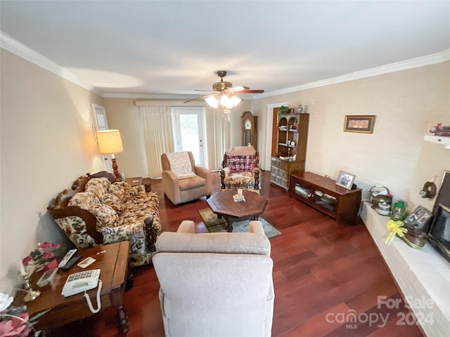 living room with dark wood-type flooring, ceiling fan, and crown molding